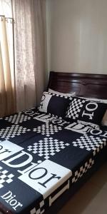 a bed with a black and white comforter on it at Shell Residences in Manila
