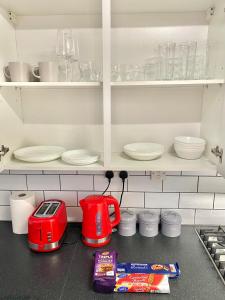a kitchen counter with a red toaster and plates at CMK Home + Garden, Train station, The Hub 5 mins in Milton Keynes