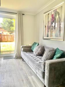 a living room with a couch and a window at CMK Home + Garden, Train station, The Hub 5 mins in Milton Keynes