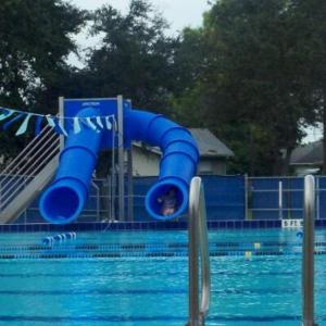 a person is on a water slide in a swimming pool at Cypress Retreat in Fort Myers