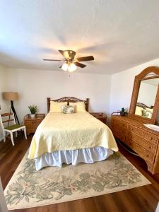 a bedroom with a bed with a ceiling fan and a mirror at Cypress Retreat in Fort Myers