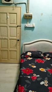 uma cama num quarto ao lado de uma porta em Hostel Dena moon inn 3 em Kota Bharu