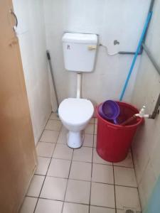 uma pequena casa de banho com um WC e um balde em Hostel Dena moon inn 3 em Kota Bharu