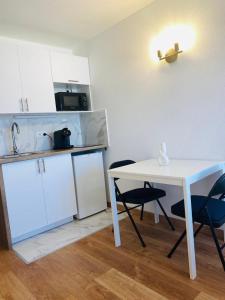 a kitchen with a white table and two chairs at Appartement Privé La Défense Paris in Courbevoie