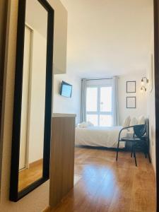einen Spiegel in einem Zimmer mit einem Bett und einem Stuhl in der Unterkunft Appartement Privé La Défense Paris in Courbevoie