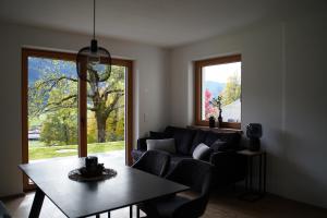 a living room with a couch and a table and a window at Alpenchalet zurHinterochsenweide SKI IN & SKI OUT in Brixen im Thale