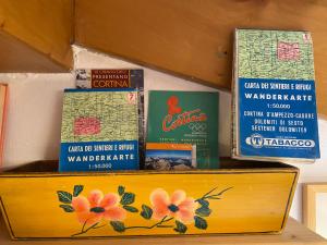une boîte en bois avec des livres sur une étagère dans l'établissement Mansardina Mery Cortina, à Cojana
