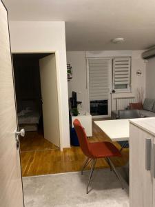 een keuken en een woonkamer met een tafel en een stoel bij Affordable Apartments 8 in Zagreb