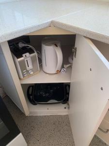 a cabinet with a counter top with a sink and a appliance at Bribie Get away in Bongaree