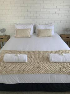 a large white bed with two pillows on it at Bribie Get away in Bongaree