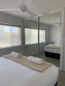 a bedroom with two beds and a mirror at Bribie Get away in Bongaree