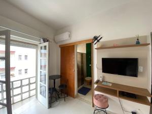 uma sala de estar com uma televisão de ecrã plano na parede em Apto Santos Gonzaga em Santos