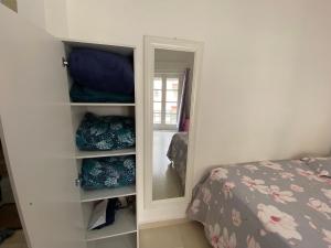 um quarto com um espelho ao lado de uma cama em Apto Santos Gonzaga em Santos