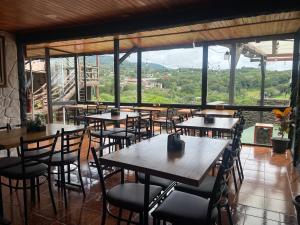 een restaurant met tafels en stoelen en een groot raam bij Cabinas Vista Al Golfo in Monteverde Costa Rica