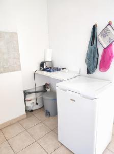 a kitchen with a white refrigerator and a sink at Appartement en centre-ville d’Uzès in Uzès