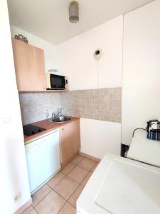 a small kitchen with a sink and a microwave at Appartement en centre-ville d’Uzès in Uzès