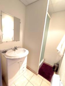 a white bathroom with a sink and a mirror at Appartement en centre-ville d’Uzès in Uzès