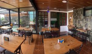 an empty restaurant with wooden tables and chairs at Cabinas Vista Al Golfo in Monteverde Costa Rica