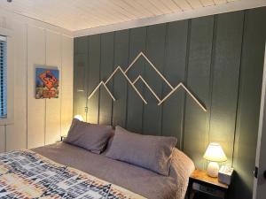 - une chambre dotée d'un grand lit et d'un mur recouvert d'aacks dans l'établissement El Osito Mountain Cabin in Angel Fire NM, à Angel Fire