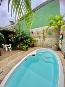 a swimming pool in a backyard with a green wall at Recanto Toca das Plantas de Ilhabela I in Ilhabela