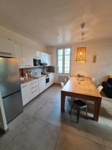eine Küche mit einem Holztisch und einem Esszimmer in der Unterkunft Appart Magnolia Villeneuve les Avignon - Provence in Villeneuve-lès-Avignon