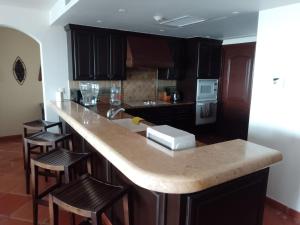 a kitchen with a large island with bar stools at delfines 204 in Cabo San Lucas