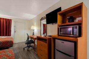 a hotel room with a desk and a microwave at Econo Lodge Goldsboro Hwy 70 in Goldsboro