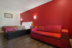 um quarto vermelho com uma cama e um sofá em Econo Lodge Goldsboro Hwy 70 em Goldsboro