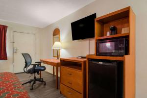 a hotel room with a bed and a desk with a microwave at Econo Lodge Goldsboro Hwy 70 in Goldsboro