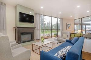 a living room with a blue couch and a fireplace at Comfort Suites Idaho Falls in Idaho Falls