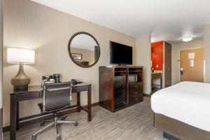 a hotel room with a bed and a desk and a mirror at Comfort Inn Troutdale-Portland East in Troutdale