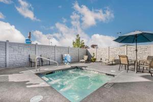 a swimming pool with a table and chairs and an umbrella at Comfort Inn Troutdale-Portland East in Troutdale
