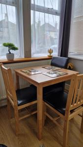a wooden table with two chairs and a plant on it at Spacious 1 Br Near Lincoln City Centre Amenities in Lincoln
