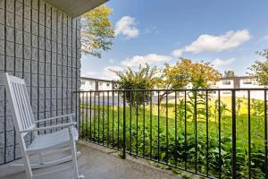 a white chair sitting on a balcony with a fence at The Lux Hotel & Conference Center, Ascend Hotel Collection in Waterloo