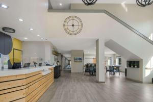 a kitchen and living room with a clock on the wall at Quality Inn & Suites Roanoke - Fort Worth North in Roanoke