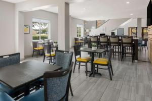 a dining room with tables and chairs in a restaurant at Quality Inn & Suites Roanoke - Fort Worth North in Roanoke