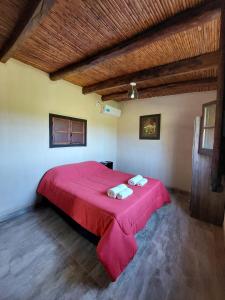 a bedroom with a red bed with two towels on it at BODEGA Y ALOJAMIENTO DON VEGA in Tinogasta