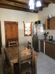a kitchen with a wooden table and a refrigerator at La Tapera in Guaymallen