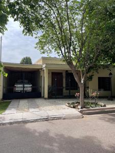 una casa con un árbol delante de ella en La Tapera en Guaymallén