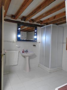 Baño blanco con lavabo y espejo en La Majada del Puente, en El Royo