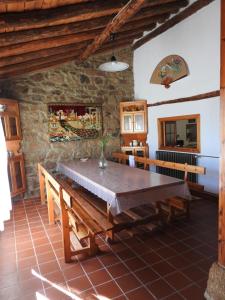 a dining room with a large wooden table and benches at La Majada del Puente in El Royo
