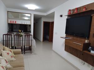 uma sala de estar com um sofá e uma televisão de ecrã plano em LAZER EM GUARAJUBA em Guarajuba