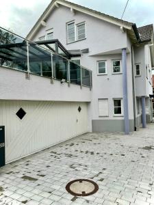 ein weißes Haus mit vielen Fenstern und einer Auffahrt in der Unterkunft flexible, schöne und gut aussehende Feriensuite (für Stadtliebhaber, Shopper, Naturliebhaber und Entspannungssuchende) in Reutlingen