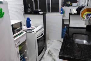 a small kitchen with a stove and a sink at Linda vista p/ Pão de Açúcar, área nobre, praias. in Rio de Janeiro