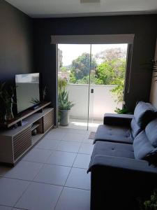 a living room with two blue couches and a television at Apartamento aconchegante in Ilhéus