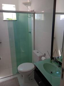 y baño con ducha, aseo y lavamanos. en Apartamento aconchegante en Ilhéus