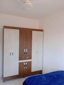 伊列烏斯的住宿－Apartamento aconchegante，一间卧室,卧室内设有一个大型木制橱柜