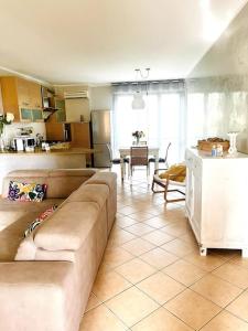 ein Wohnzimmer mit einem Sofa und einer Küche in der Unterkunft La Casa nel Verde in Pistoia