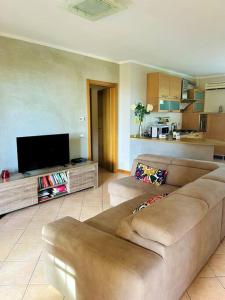 ein Wohnzimmer mit einem Sofa und einem Flachbild-TV in der Unterkunft La Casa nel Verde in Pistoia