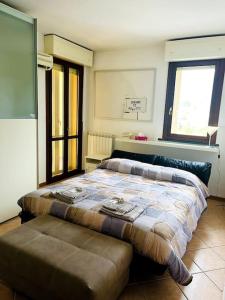 a bedroom with a bed and a ottoman in it at La Casa nel Verde in Pistoia